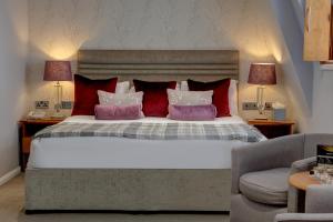 伦敦Corus Hyde Park Hotel的一间卧室配有一张带红色和白色枕头的大床