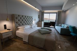 AiándionAianteion Bay Luxury Hotel & Suites的一间卧室配有一张大床和一张沙发