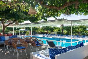 扎金索斯镇Sirocco Hotel的一个带桌椅的游泳池和一个游泳池
