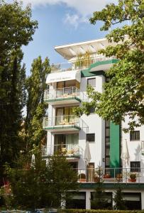 柏林Bernstein Hotel Villa Kastania的带阳台和树木的白色建筑