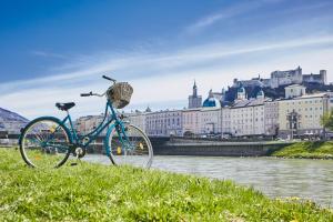 萨尔茨堡优博夫尔精品酒店的停在河边的草上一辆蓝色的自行车