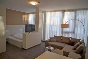奥芬巴赫奥芬巴赫瑟维斯公寓式酒店的带沙发和平面电视的客厅
