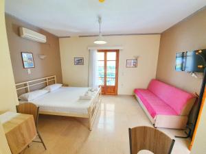 雷夫卡达镇Alexaria Holidays Apartments的客房设有床、沙发和桌子。