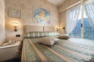 切尔诺比奥米罗拉歌酒店的一间卧室配有一张床、电话和窗户