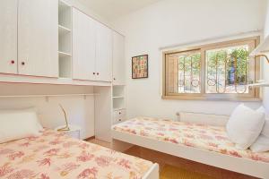 菲纳莱利古雷Villa Cuckoo's Nest的一间卧室设有两张床和窗户。