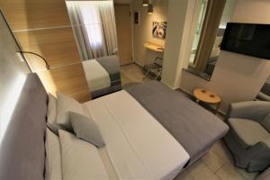 雅典Aiolos Apartments Ermou 64 4th Floor的配有床、椅子和电视的房间