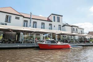 阿克伦古勒斯餐厅酒店的建筑物前水面上的红船