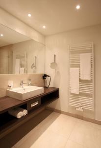 格尔德恩詹森希尔公园酒店的一间带水槽和镜子的浴室