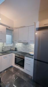 纳夫普利翁Di fronte alla fortezza的厨房配有白色橱柜和不锈钢冰箱