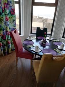 纽卡斯尔Conlyn house的用餐室配有带紫色盘子和椅子的桌子