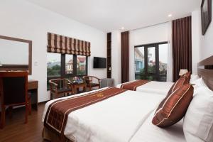 宁平Diamond Hotel的酒店客房设有两张床、一张书桌和窗户。