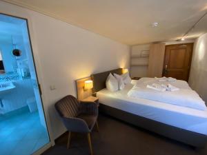 蒙绍霍岑酒店-餐厅-咖啡厅-酒吧的配有一张床和一把椅子的酒店客房