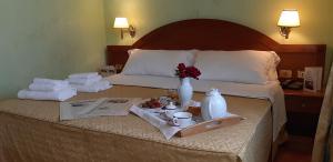 格罗塔费拉塔斯夸尔西亚雷里酒店的酒店客房,配有一张带毛巾的床和食品托盘