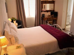 蒙帕齐耶切斯埃戴尔宾馆的一间卧室配有一张大床,上面有红毯