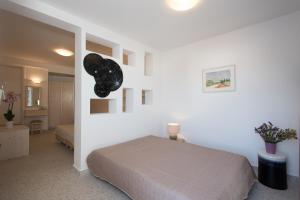 米克诺斯城斯潘纳里斯酒店的一间白色客房内的床铺卧室