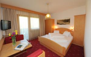 普拉托·阿罗·斯泰尔维奥斯特恩宾馆的酒店客房设有一张大床和一张桌子。
