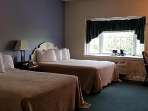 WilmotInn at Amish Door的酒店客房设有两张床和窗户。