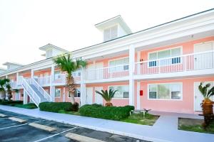 沃尔顿堡滩Tropical Isle #205的停车场内棕榈树的公寓楼