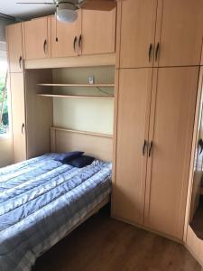 阿雷格里港POA zona norte - melhor opção - completíssimo的一间卧室配有一张床和木制橱柜