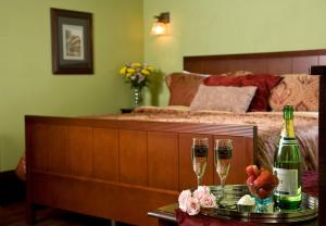 温泉城Hilltop Manor B&B的一间卧室配有一张床和两杯香槟
