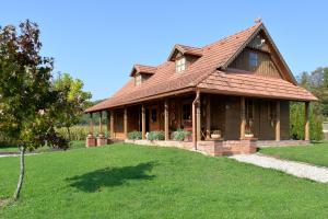 MaruševecOld Oak House with pool的绿色草坪上带屋顶的大房子