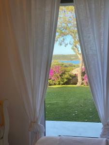 切尔沃港Residence Gli Oleandri 128 - Costa Smeralda - Porto Cervo的卧室设有窗户,享有庭院的景色