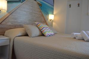格拉多梅拉诺酒店的一间卧室配有一张大床和木制床头板