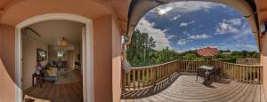贝诺代拉菲儿梅乡间渡假别墅酒店的阳台享有带遮阳伞的甲板的景致。