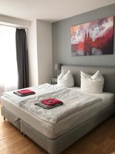 科隆City Apartment am Dom的一间卧室配有一张大床,上面有红色的毛巾