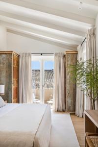 赫雷斯-德拉弗龙特拉Hotel Bodega Tio Pepe的一间卧室设有一张大床和一个大窗户