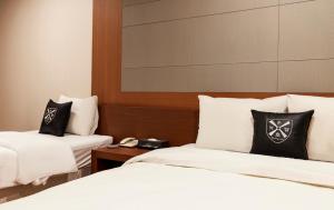 仁川市仁川爱特尔酒店的酒店客房带两张床铺以及黑白枕头