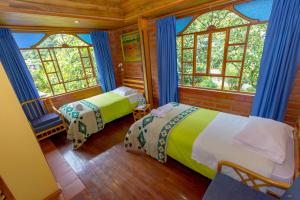 巴尼奥斯Hotel y Spa Isla de Baños的一间带两张床的卧室,位于带窗户的房间内
