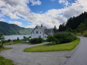 LauvstadIrenegarden - Fjord view holiday home的湖畔道路边的房子