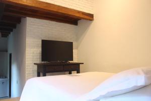托兰克索Calypso INN的一间卧室配有一张床和一台平面电视