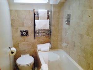 哈罗盖特圆弧精品B&B旅馆的带浴缸、卫生间和盥洗盆的浴室