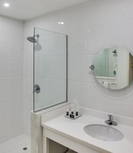 金斯敦利瓜尼亚俱乐部酒店的白色的浴室设有水槽和镜子