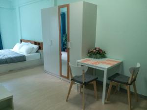 曼谷DD Garden Apartment 2的卧室配有一张床和一张桌子及椅子