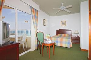 科拉雷侯Hotel Riu Oliva Beach Resort - All Inclusive的一间卧室配有一张床、一张桌子和一台电视