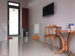 Xã Gia TânKhách Sạn Today的一间设有木椅和墙上电视的房间