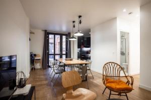 巴黎舍曼韦尔顶楼公寓的客厅设有餐桌和椅子
