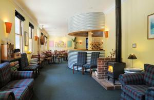 沃尔哈拉瓦尔哈拉之星酒店 的餐厅配有沙发、椅子和壁炉
