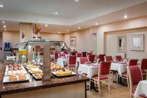 巴塞罗那日光青少年酒店的餐厅配有桌椅,柜台供应食物