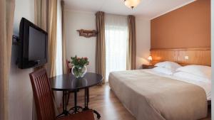 派尔努维赛特酒店别墅的酒店客房设有一张床和一张桌子及一台电视