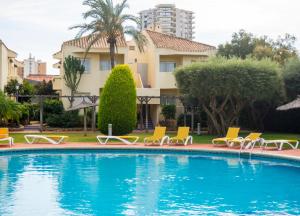 拉曼加戴尔马尔梅纳拉曼加别墅公寓酒店的一座带躺椅的游泳池和一座建筑
