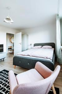 格丁尼亚Gdynia Square Apartment的一间卧室配有一张大床和两把椅子