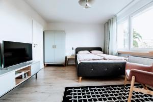 格丁尼亚Gdynia Square Apartment的一间卧室配有一张床和一台平面电视