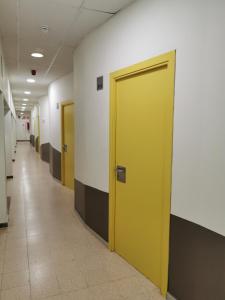 科马鲁加Alberg Coma-ruga Xanascat的大楼内带两扇黄色门的走廊