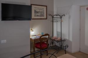 卡斯泰洛城Città Di Castello Rooms的客房设有书桌、椅子和电视。