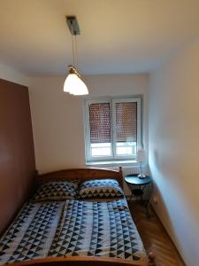 索普隆ALEX Apartman的一间卧室配有一张床、一盏灯和两个窗户