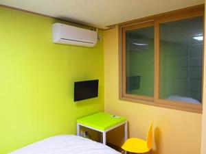 首尔清溪酒店的绿色的客房设有床、桌子和窗户